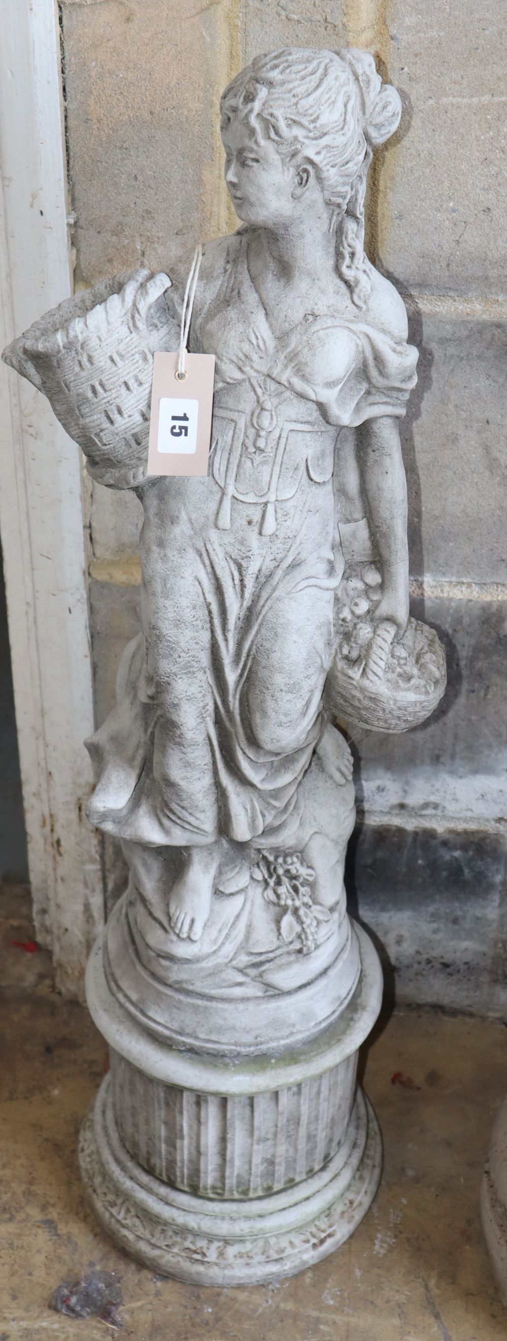 A reconstituted stone garden ornament, girl with baskets of fruit, H.90cm
